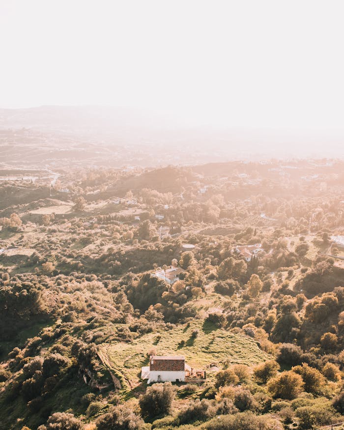 A breathtaking aerial view of the lush countryside in Mijas, Spain, captured at sunset.